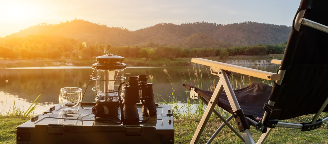 Een kopje koffie drinken in een campingstoel met een prachtig uitzicht op een meer en heuvels