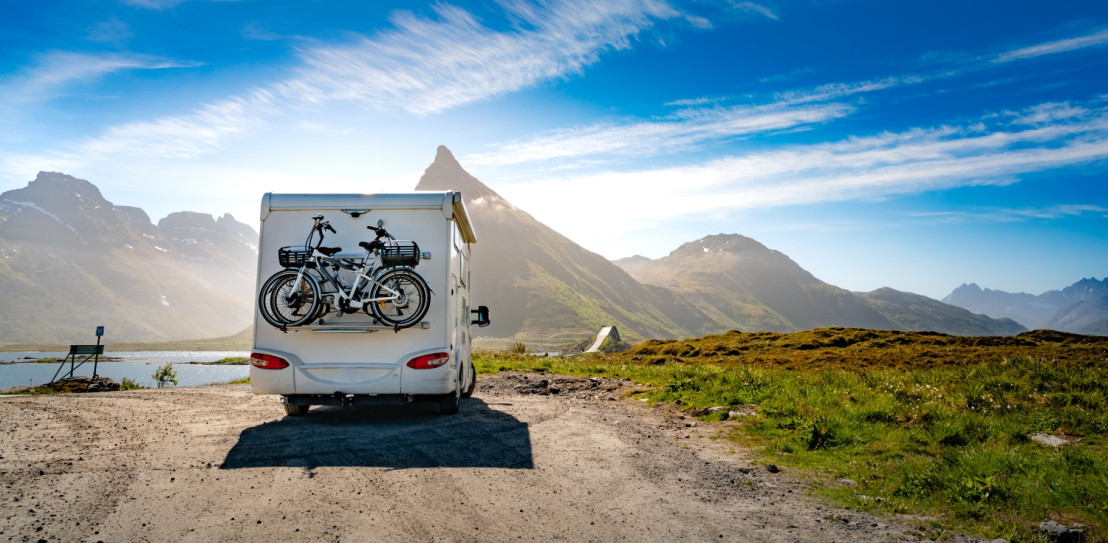 Camper staat op een camperplaats in de bergen vlakbij een bergmeer