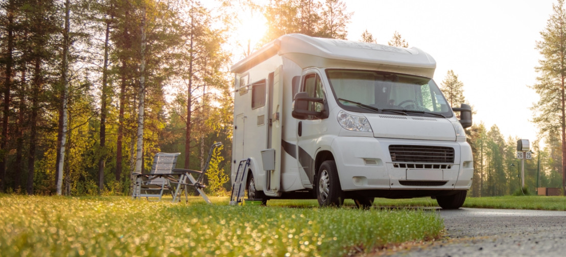 De camper staat hier op een camperplaats in een bosrijke omgeving