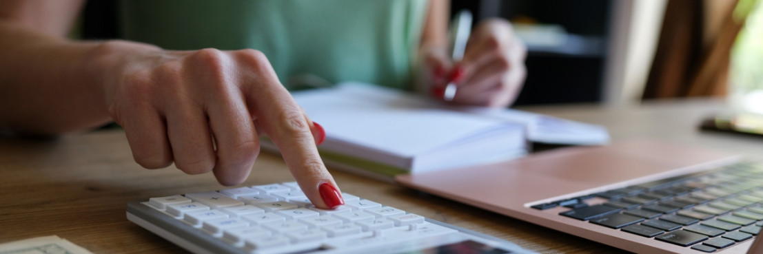 Vrouw berekent handmatig de verhuuropbrengsten en commissies uit