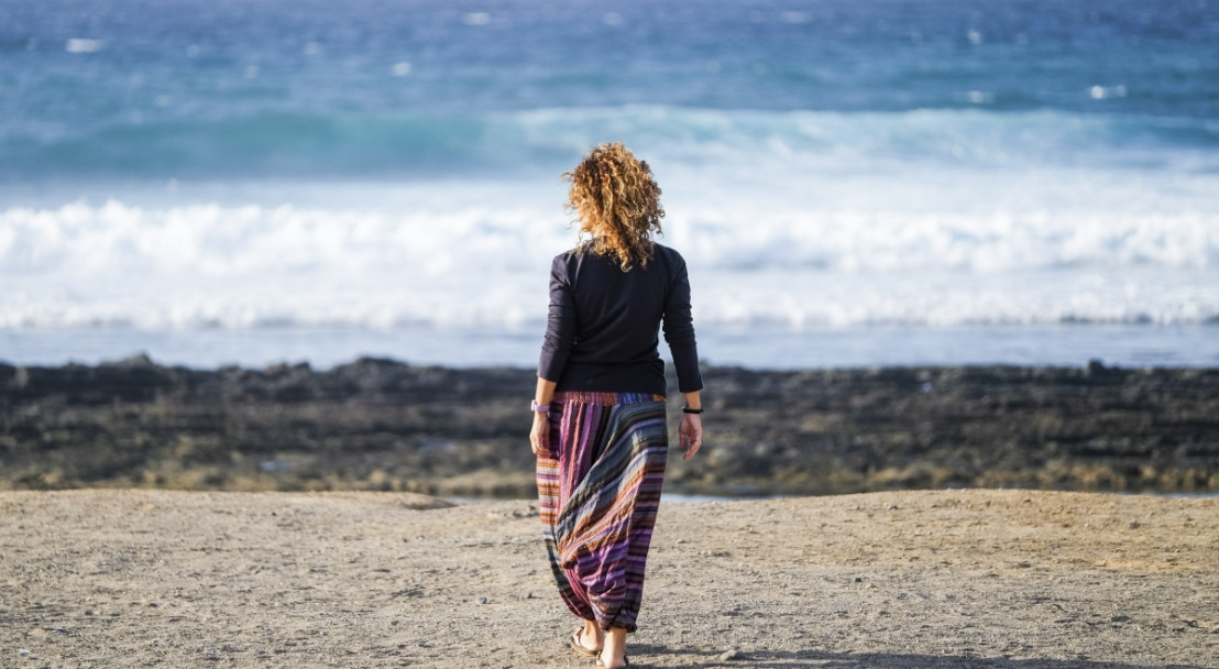 Vrouw loopt strand op richting zee bij nord pas de calais