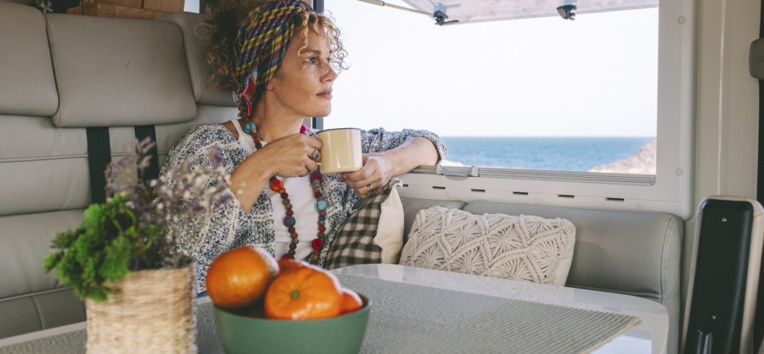 Vrouw zit in een camper en denkt erover na om haar camper te gaan verhuren